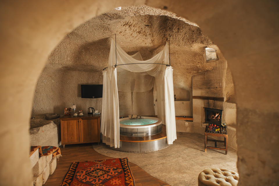 A cave suite with a jacuzzi and a fireplace