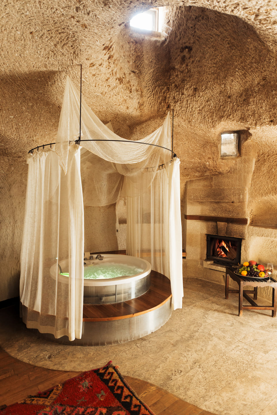 A jacuzzi suite with the fire lit