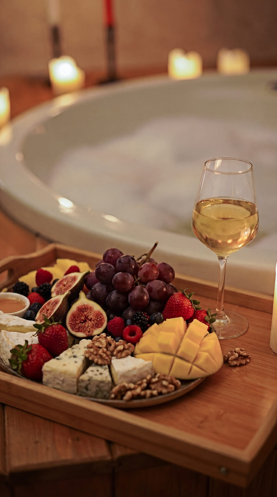 A candlelit bath with a fruit and cheese board
