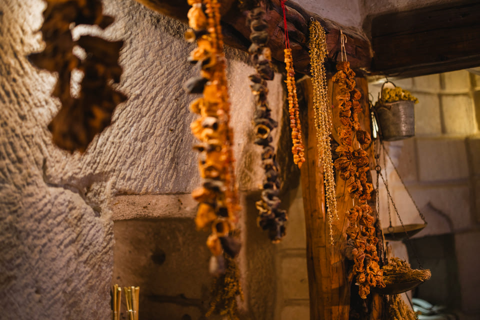Dried peppers and aubergines hung along the stone wall