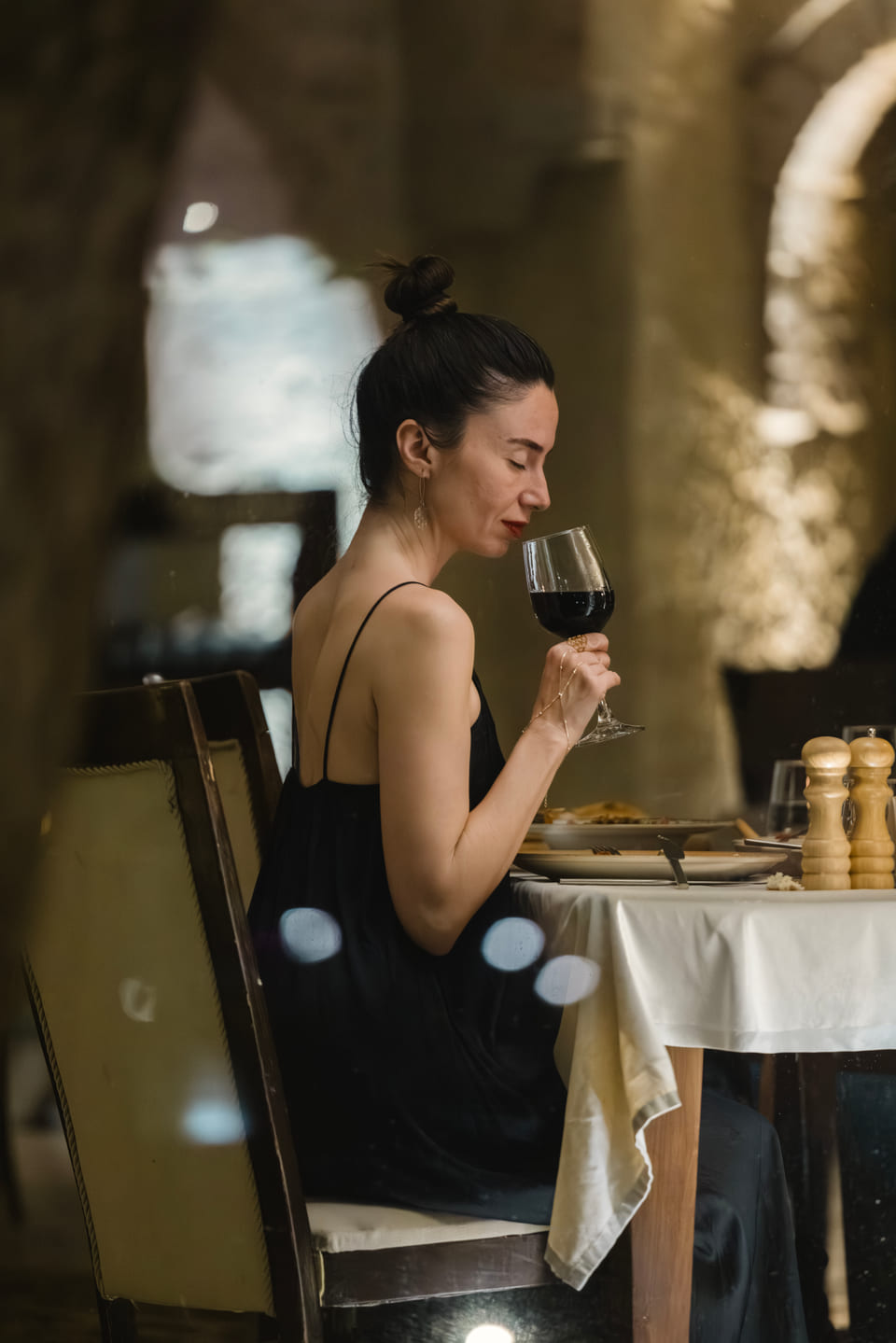 A guest with a glass of red wine at Alâ Restaurant
